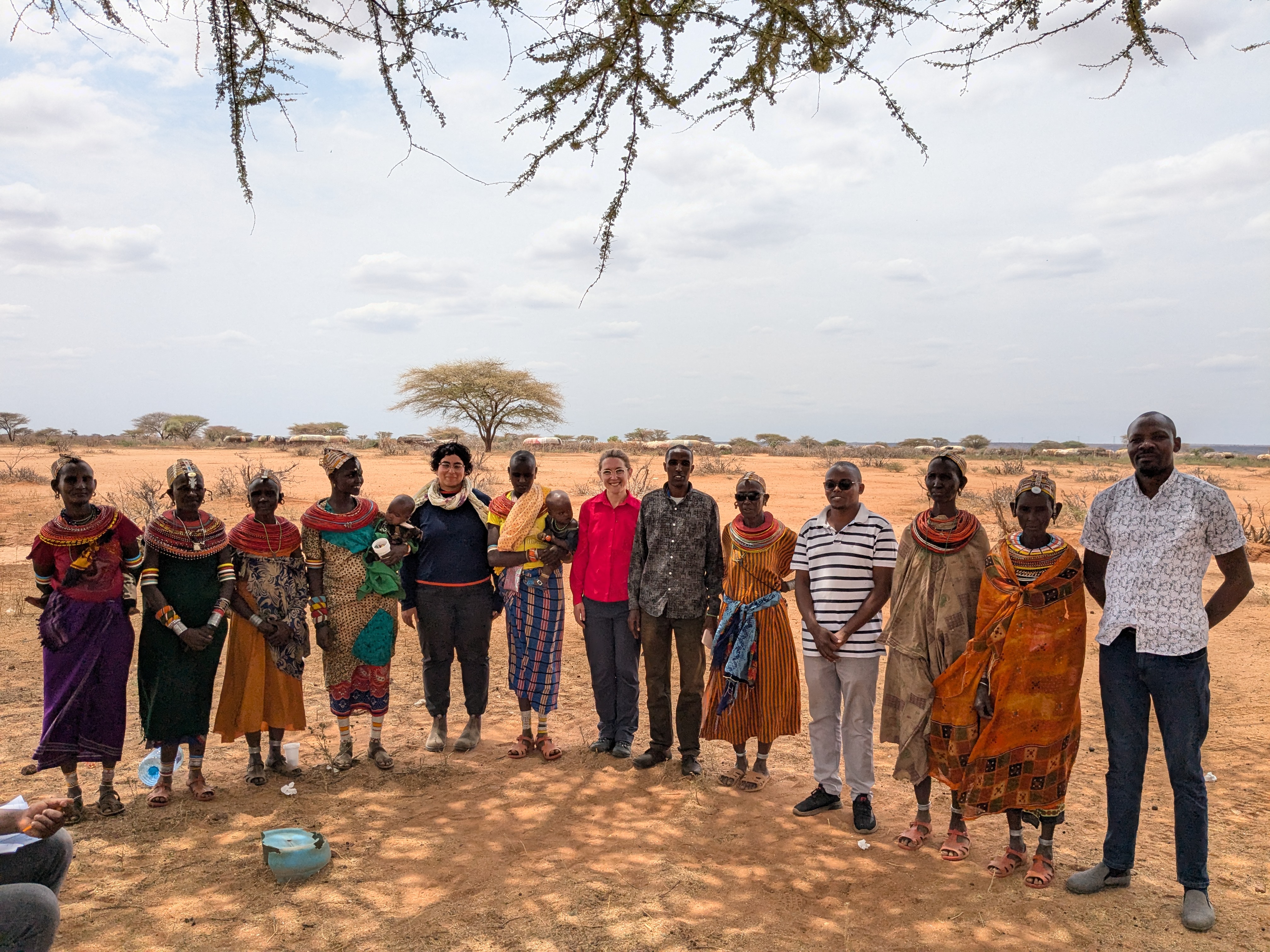 Women and researchers pose together for a photo after a focus group discussion; photo by Arthur Orieny; Laisamis, Kenya, 2024